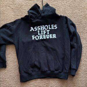 Black Graphic Hoodie with Bold Front Text “Assholes Lift Forever”